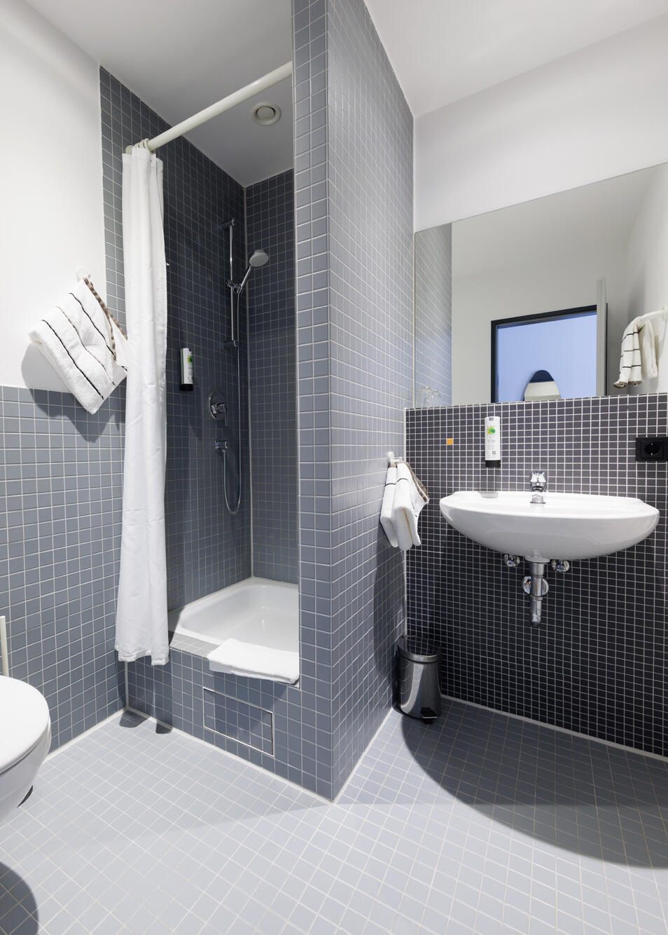 Badezimmer mit Waschbecken, Dusche und WC im Internationalen Studierendenhotel