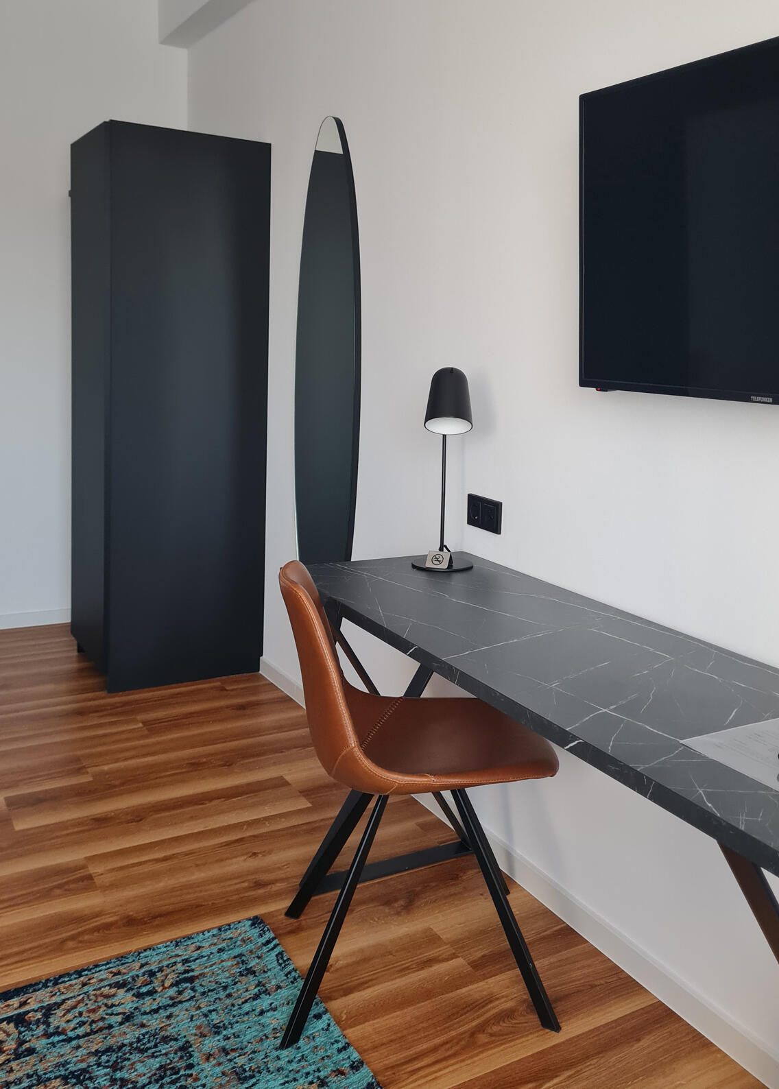 Double room with wardrobe, mirror, desk, chair, desk lamp and TV in the International Student Hotel