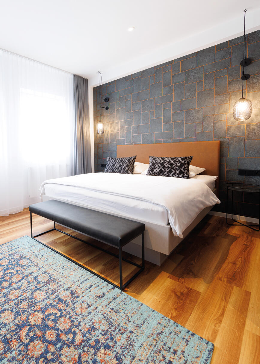 Doppelzimmer mit Schreibtisch, Stühlen und Teppich im Internationalen Studierendenhotel