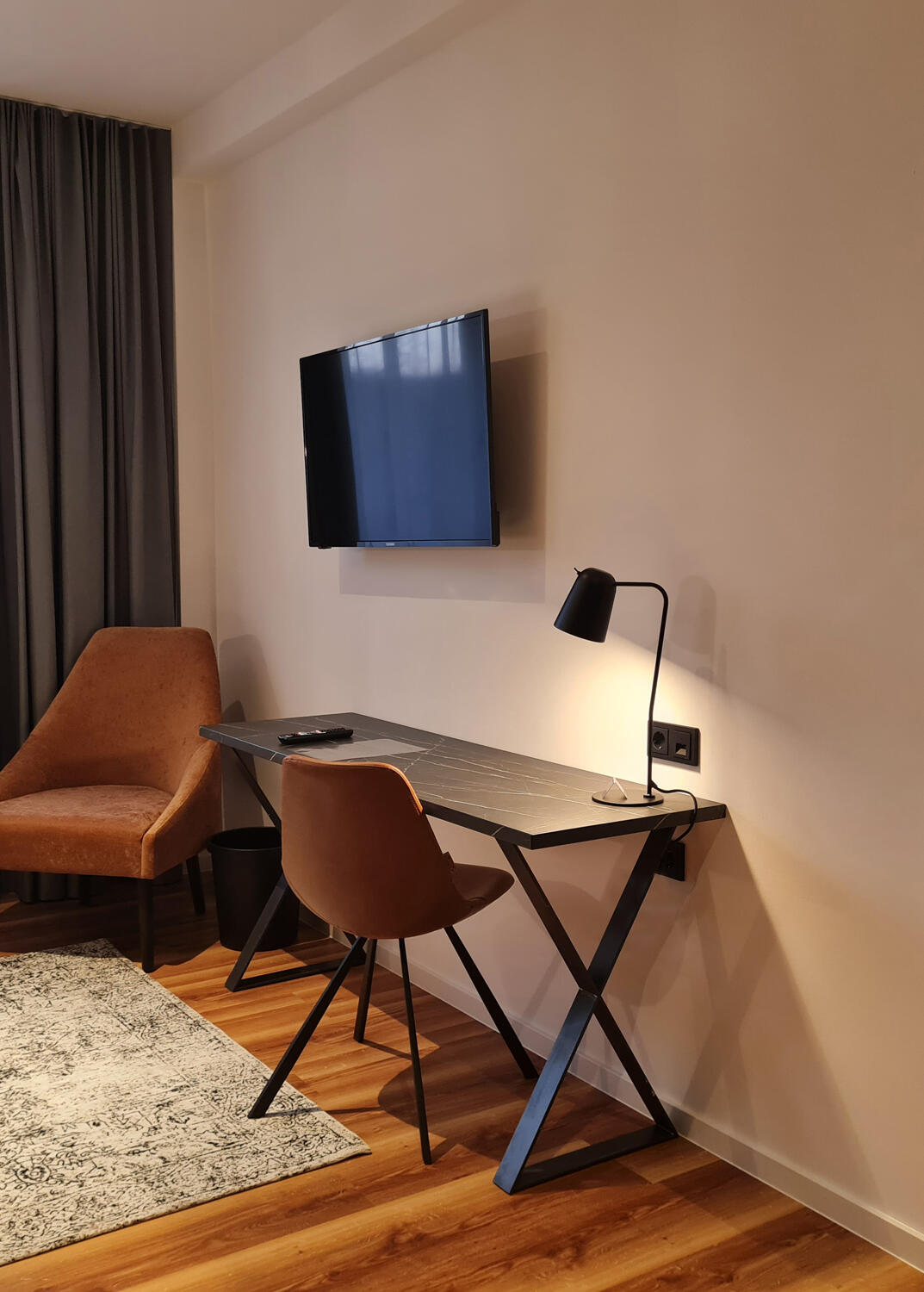 Double room with mirror, desk, chairs, desk lamp, carpet and TV in the International Student Hotel